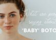 A red-headed young woman with blue eyes, freckles, and pink lips, stands in front of a baby blue background. Text reads in white cursive:"What are people saying about," followed by white block letters: "'BABY' BOTOX?"